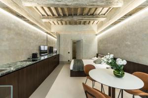 ein Hotelzimmer mit Bett, Tisch und Stühlen in der Unterkunft CHIAROMANNI SUITE in Arezzo