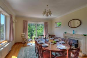 a dining room with a table and chairs and a fireplace at Westdale Edge in Seaton