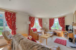 a living room with red curtains and a couch at Barn Close Farm in Morecombelake