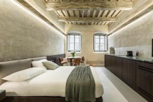 ein Schlafzimmer mit einem Bett und einem Tisch mit Stühlen in der Unterkunft CHIAROMANNI SUITE in Arezzo