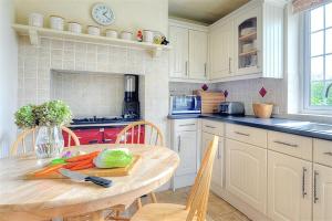 a kitchen with a wooden table with vegetables on it at Barn Close Farm in Morecombelake