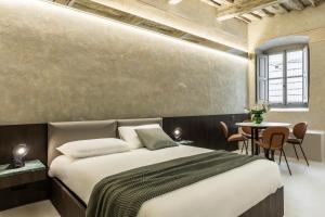 ein Schlafzimmer mit einem Bett und einem Tisch mit Stühlen in der Unterkunft CHIAROMANNI SUITE in Arezzo