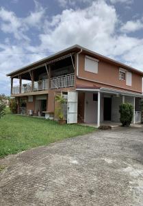 a large house with a porch and a yard at Studio Griyav- dans villa les Polycias in Sainte-Luce