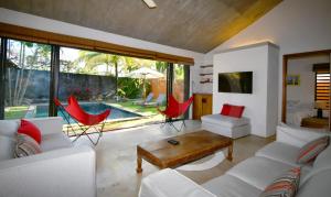 salon z białą kanapą i czerwonymi krzesłami w obiekcie Elegant Villa with pool and privacy Blue Bay w mieście Blue Bay