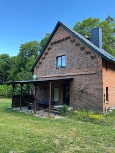 an old brick house with a porch and a porch at Forsthof Waldblick Karow in Karow