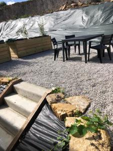 un patio con tavolo, sedie e tenda di Eden, F3 avec extérieur et parking a Ver-sur-Mer