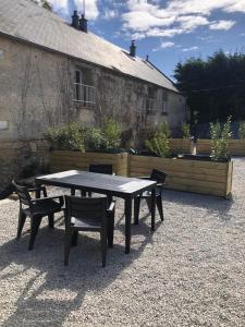 a picnic table and chairs in front of a building at Eden, F3 avec extérieur et parking in Ver-sur-Mer