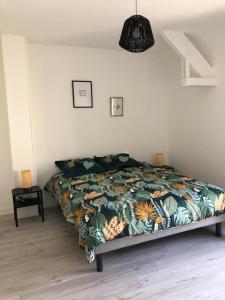 a bedroom with a bed with a colorful blanket at Eden, F3 avec extérieur et parking in Ver-sur-Mer