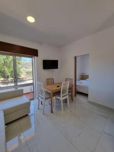 a living room with a table and chairs and a bed at AAA Apartments in Albufeira