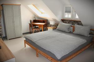 a bedroom with a bed and a desk and a piano at Forsthof Nunkirchen in Wadern