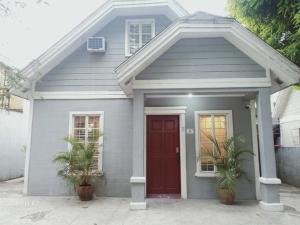 サンタローザにあるLaguna Bel-Air Home in Sta Rosa #15 by Red Door House Rentalの赤い扉と鉢植えの植物が2つある家