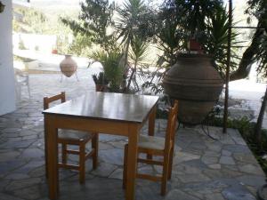 ein Holztisch, zwei Stühle und eine Vase in der Unterkunft Ktena Apartments in Platanias