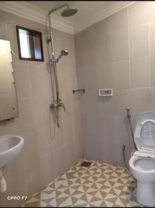 une salle de bain avec une douche, des toilettes et un lavabo dans l'établissement Rumah Mertua Pulau Merah, à Pasanggaran 21 autres photos