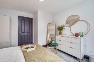 a bedroom with a bed and a mirror and a dresser at Central Belfast Apartments: Botanic in Belfast