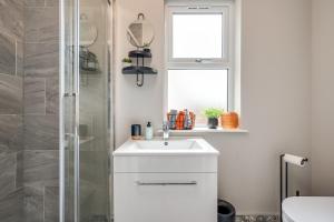 a bathroom with a white sink and a shower at Central Belfast Apartments: Botanic in Belfast