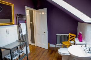 a purple bathroom with a toilet and a sink at No4 Cromer in Cromer
