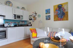 sala de estar con sofá y mesa con copas de vino en 6 Coram Tower, en Lyme Regis