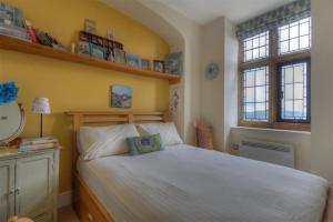 1 dormitorio con 1 cama blanca y 2 ventanas en 6 Coram Tower, en Lyme Regis