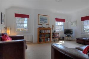 Una sala de estar con dos sofás y un televisor. en Riverview, en Lyme Regis