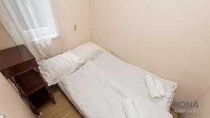 Mały pokój z łóżkiem z białą pościelą i oknem w obiekcie Rona apartment Zdenka w Poreču