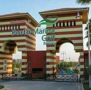 Resort de golf aventura marina con 2 arcos frente a un edificio en تمتع بالإقامة في شاليه فندقي بمنتجع جولف بورتو مارينا الساحل الشمالي - Enjoy your stay at Golf Porto Marina Resort El Alamein - North Cost en El Alamein