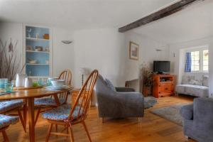 a living room with a dining room table and chairs at Ivy Cottage in Lyme Regis