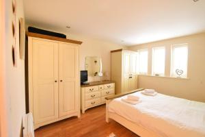 a bedroom with a white bed and a dresser at 2 Buckfields in Lyme Regis