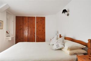 a bedroom with a large bed with white sheets and pillows at Ivy Cottage in Lyme Regis