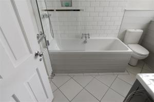 bagno bianco con vasca e servizi igienici di 2 Woodville a Lyme Regis