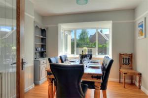 a dining room with a wooden table and chairs at 2 Grange Villas in Charmouth