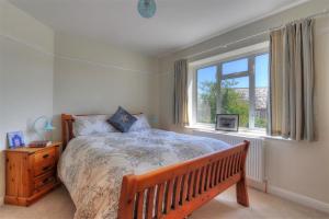 a bedroom with a large bed and a window at 2 Grange Villas in Charmouth