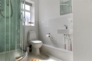 a bathroom with a toilet and a shower and a sink at 2 Grange Villas in Charmouth +13 photos