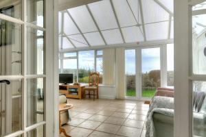 a living room with a conservatory with windows at Dolphins Leap in Charmouth