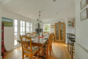 a dining room with a table and chairs at Dolphins Leap in Charmouth