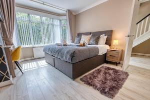 a bedroom with a bed and a large window at Stunning 5 Bed House - Sleeps 9, Central Solihull, NEC, JLR, HS2, Resorts World, Airport Business and Leisure Stays, in Solihull