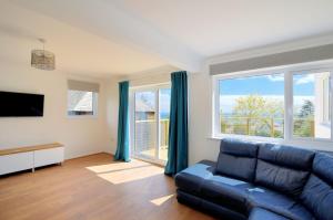 a living room with a couch and a large window at Lottys Lookout in Lyme Regis