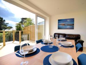 a dining room with a table and a large window at Lottys Lookout in Lyme Regis