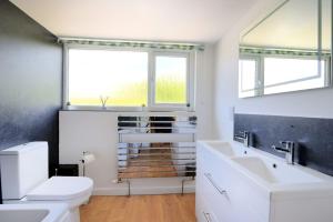 a bathroom with a toilet and a sink and a window at Lottys Lookout in Lyme Regis +22 photos