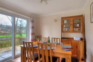 a dining room with a wooden table and a window at 4 Riverside Cottages in Charmouth