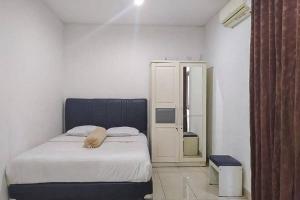 a bedroom with a bed with a blue head board at Graha HT Sumantri Mitra RedDoorz in Tasikmalaya