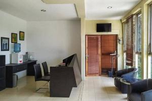 un soggiorno con scrivania, sedie e TV di Graha HT Sumantri Mitra RedDoorz a Tasikmalaya