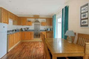 uma cozinha com armários de madeira e uma mesa de jantar de madeira em 8 Buckfields em Lyme Regis