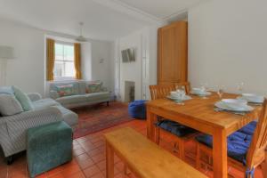 ein Wohnzimmer mit einem Holztisch und einer Couch in der Unterkunft Monmouth Cottage in Lyme Regis