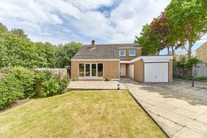 a brick house with a garage in a yard at Xanadu: Stylish Family Home by the Pub and Beach in Beadnell