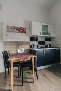 a kitchen with a table and chairs and a kitchen with a counter at Palmers Apartments and Rooms in Zagreb