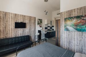 a bedroom with a couch and a tv on a wall at Palmers Apartments and Rooms in Zagreb
