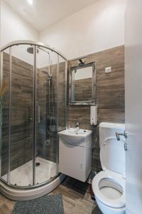 a bathroom with a shower and a toilet and a sink at Palmers Apartments and Rooms in Zagreb