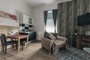 a living room with a table and a kitchen at Palmers Apartments and Rooms in Zagreb