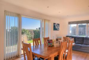 a dining room with a wooden table and chairs at Pendower in Charmouth