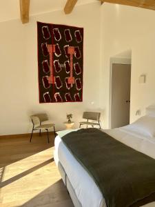 a bedroom with a bed and a painting on the wall at Domaine de Panery in Pouzilhac